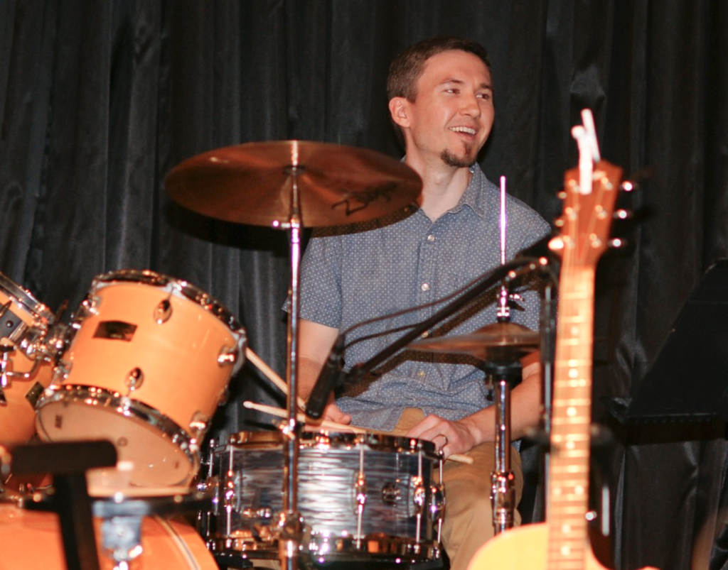 man drumming on a drum set