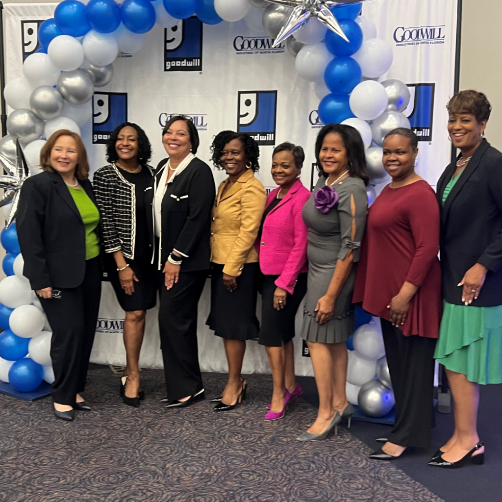 women in front of goodwill banner