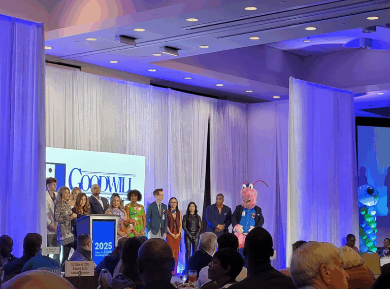 attendees on stage at the gather for goodwill luncheon