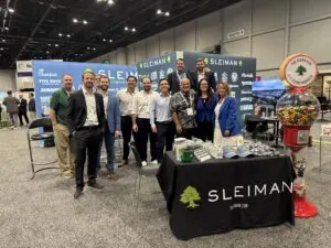 Group of people at Sleiman Enterprises booth during ICSC Florida 2026 event.